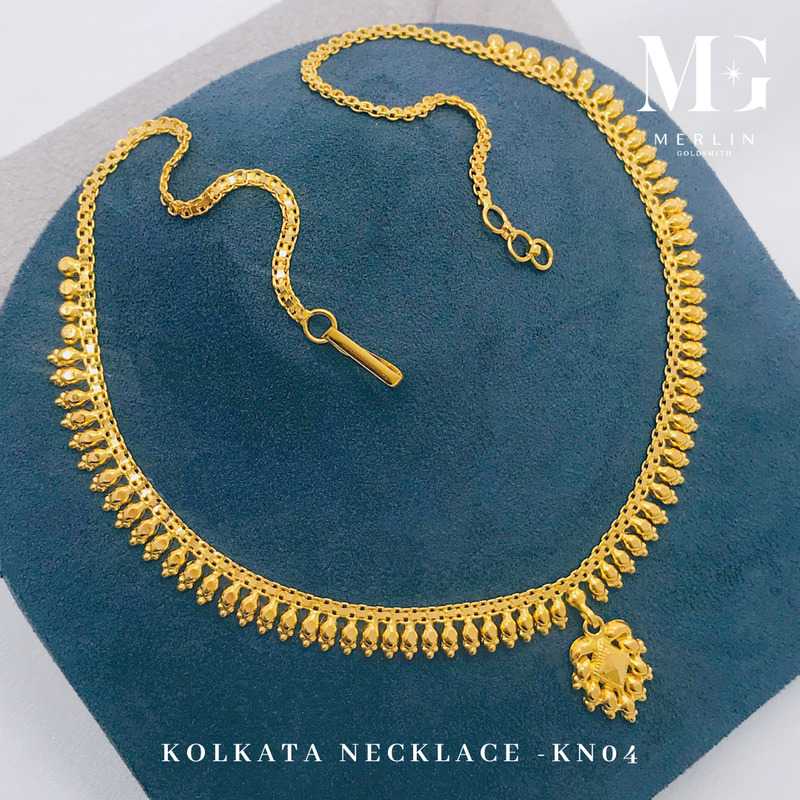 Gold Kolkata necklace KN04 with a decorative bead fringe, a small pendant and an adjustable chain extension on a blue display stand from Merlin Goldsmith
